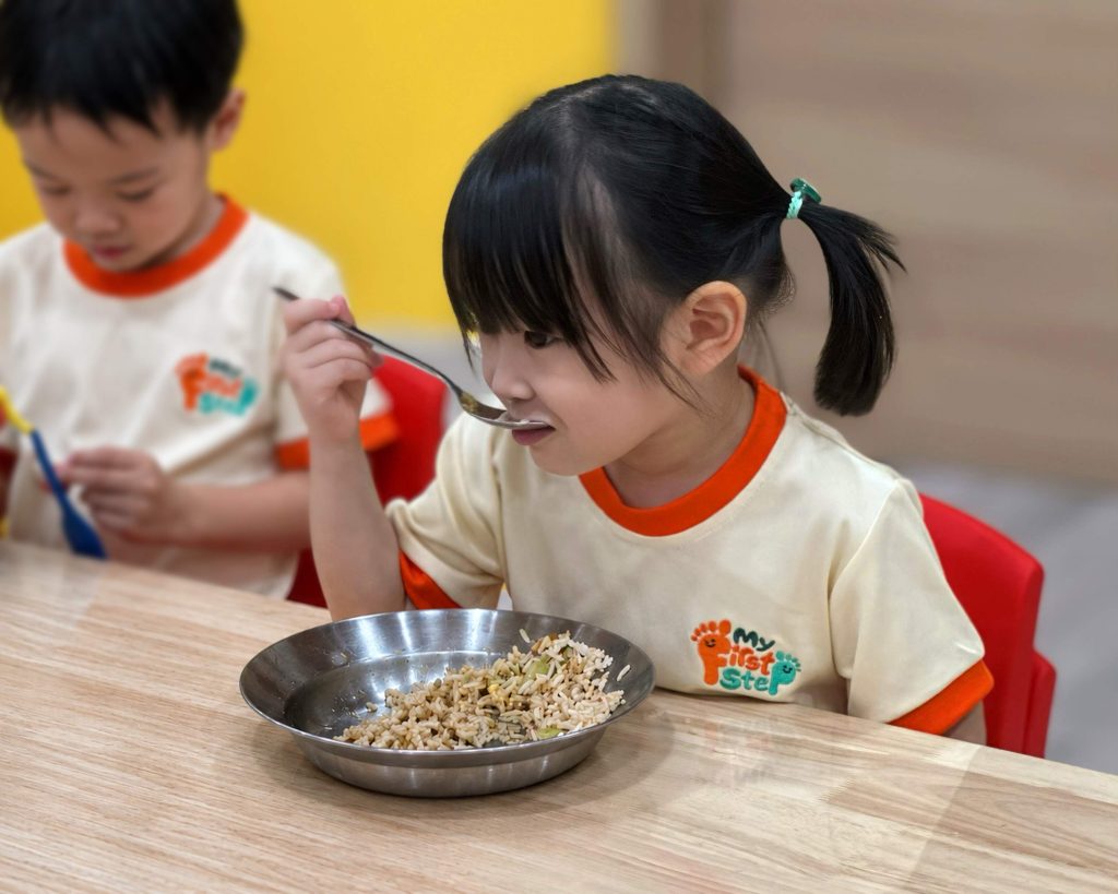 Preschool children sitting together at lunchtime at a Taska in Petaling Jaya